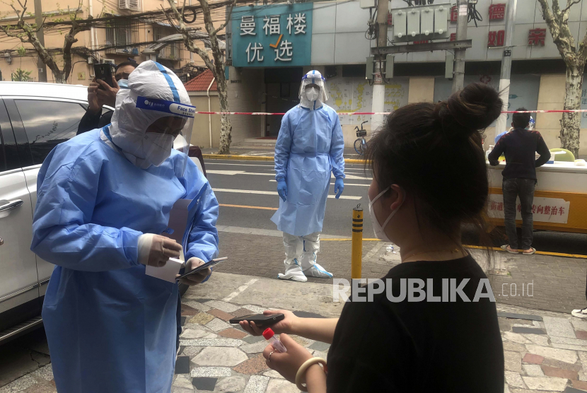 Tenaga medis melakukan tes COVID-19 bagi warga setelah ditemukan kasus terkonfirmasi di masyarakat pada Minggu, 10 April 2022, di Shanghai. Pembatasan di Shanghai membuat pasien non-Covid sulit mendapat bantuan medis. Ilustrasi.