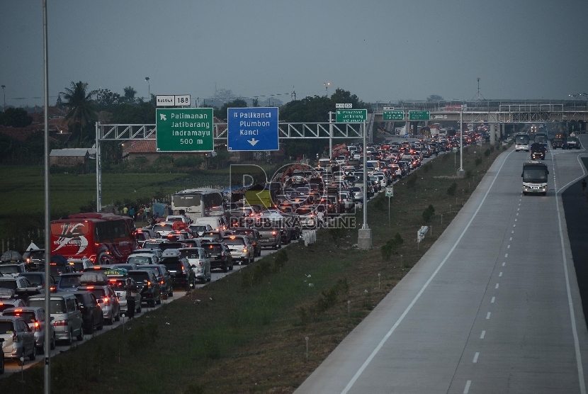 Petugas kepolisian mengatur lalu lintas ribuan kendaraan terjebak kemacetan dari Km 194 Ruas Jalan Tol Cipali hingga Km 210 ruas Jalan Tol Palikanci, Jawa Barat.