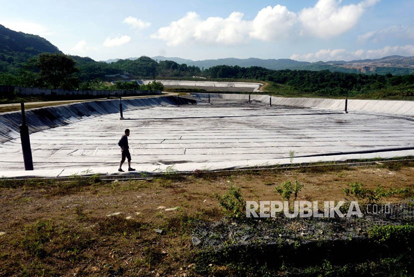 Warga melintas di Tempat Pengolahan dan Pemrosesan Akhir Sampah (TPPAS) Lulut Nambo yang belum beroperasi di Kelapa Nunggal, Kabupaten Bogor, Jawa Barat, Senin (9/4).