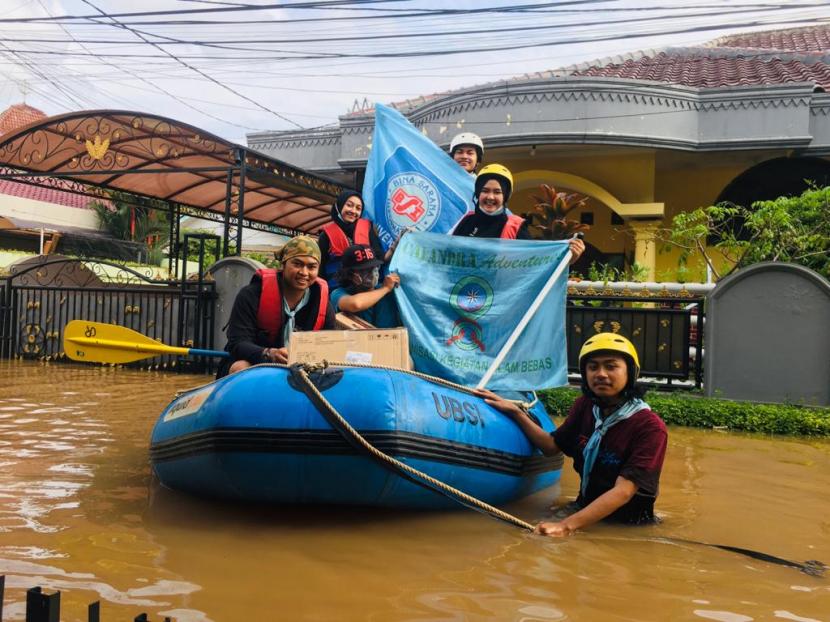 Unit Kegiatan Mahasiswa (UKM) Pecinta Alam Kampus UBSI membantu evakuasi korban yang terjebak bencana Banjir di daerah Cipinang Melayu, Makasar, Jakarta Timur, Sabtu (20/2/2022).