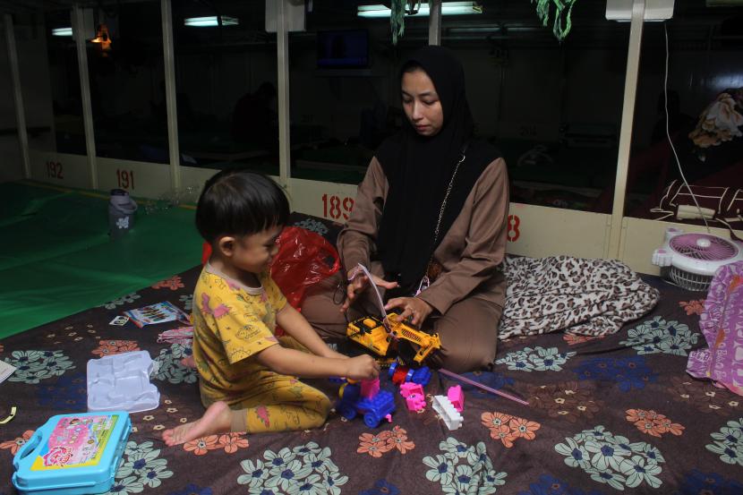 Penumpang kapal Anggun (kanan) bermain bersama anaknya di ruang kelas ekonomi KM Bukit Raya rute Pontianak-Kepulauan Riau saat menunggu keberangkatan di Pelabuhan Dwikora, Pontianak, Kalimantan Barat, Jumat (22/4/2022). Kepala Operasi PT Pelni (Persero) Pontianak Mulyadi mengatakan pihaknya memprediksi puncak arus mudik lebaran di Pelabuhan Dwikora akan terjadi pada Jumat (29/4/2022) yaitu saat keberangkatan Kapal Motor (KM) Bukit Raya tujuan Surabaya.