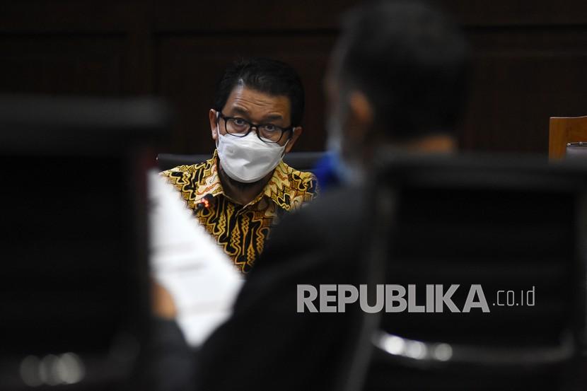Terdakwa mantan Deputi Komisioner Pengawas Pasar Modal II Otoritas Jasa Keuangan (OJK) Fakhri Hilmi (kiri) mendengarkan keterangan ahli pada sidang lanjutan perkara korupsi pengelolaan keuangan dan dana investasi PT Asuransi Jiwasraya (Persero) di Pengadilan Tipikor, Jakarta, Kamis (29/4/2021). Sidang beragenda mendengarkan keterangan dua ahli yang dihadirkan JPU Kejaksaan Agung.