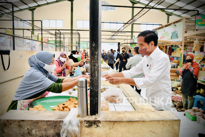 Presiden Joko Widodo (kanan) mengecek harga dan ketersediaan sejumlah bahan kebutuhan pokok masyarakat di Pasar Rakyat Desa Tempurejo, Kecamatan Tempuran, Kabupaten Magelang, Jawa Tengah, Rabu (30/3/2022).