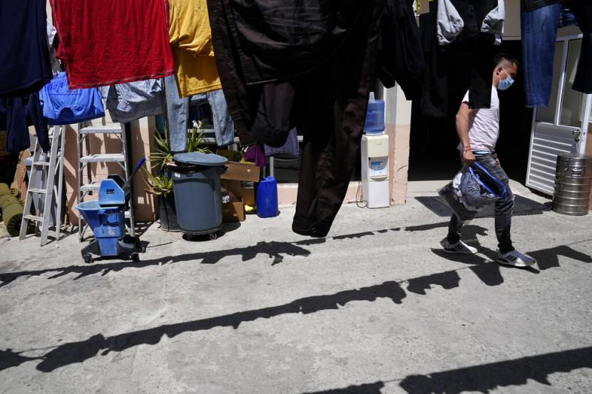 Juan, dari Kolombia, menjemur pakaiannya di tempat penampungan para migran Kamis, 21 April 2022, di Tijuana, Meksiko. Juan, yang telah kembali ke Meksiko setelah mencoba menyeberang ke Amerika Serikat untuk mengajukan suaka, harus menunggu hingga awal Mei untuk sidang berikutnya. Kebijakan kritis era Trump yang memaksa pencari suaka untuk menunggu di Meksiko untuk sidang di pengadilan imigrasi AS akan diajukan Selasa di hadapan Mahkamah Agung AS.