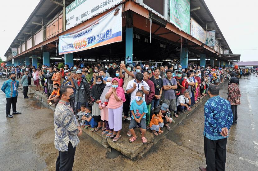 Sejumlah warga memadati bagian tepi salah satu bangunan saat menunggu kedatangan Presiden Joko Widodo di Pasar Modern Angso Duo, Jambi, Kamis (7/4/2022). Dalam kunjungannya ke pasar terbesar di Jambi itu, Presiden Joko Widodo juga menyerahkan bantuan modal kerja dan Bantuan Langsung Tunai (BLT) minyak goreng untuk sejumlah pedagang dan keluarga penerima manfaat.