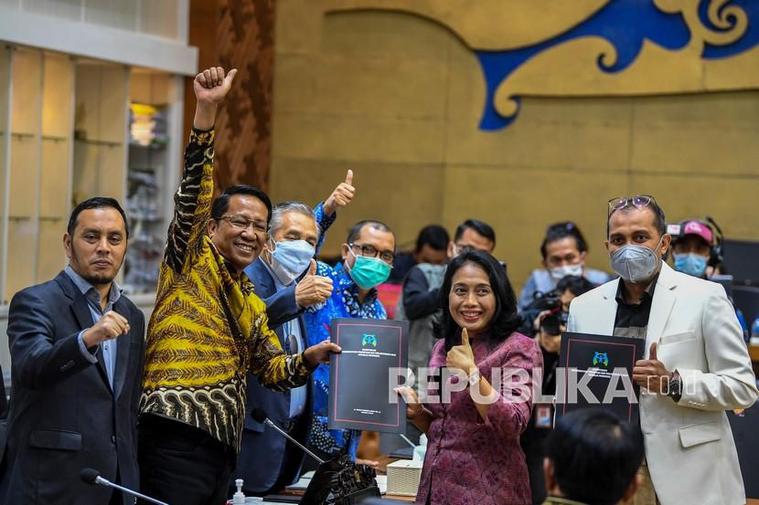 Menteri Pemberdayaan Perempuan dan Perlindungan Anak I Gusti Ayu Bintang Darmawati Puspayoga (kedua kanan) bersama Wakil Menteri Hukum dan HAM Edward Omar Sharif Hiariej (kanan) menyerahkan tanggapan pemerintah kepada Ketua Badan Legislasi (Baleg) DPR Supratman Andi Agtas (kedua kiri) disaksikan sejumah pimpinan Baleg saat Rapat Pleno pengambilan keputusan atas hasil pembahasan RUU tentang Tindak Pidana Kekerasan Seksual dengan Badan Legislasi DPR di Kompleks Parlemen, Senayan, Jakarta, Rabu (6/4/2022). Dalam Rapat pleno tersebut Badan Legislasi DPR menyetujui Rancangan Undang-Undang Tindak Pidana Kekerasan Seksual (RUU TPKS) untuk segera disahkan jadi undang-undang dalam Rapat Paripurna.