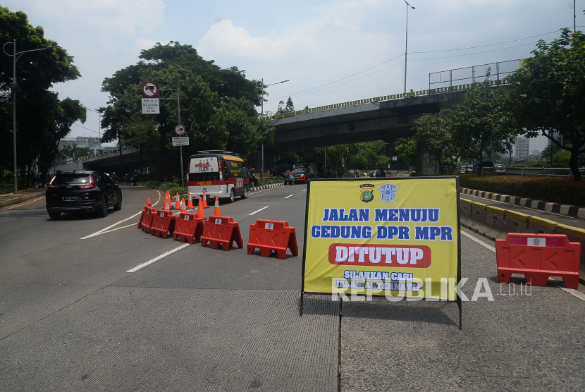 Kendaraan melintas disamping papan informasi penutupan jalan di Sekitar Kawasan gedung DPR, Senayan, Jakarta. Polda Metro Jaya siapkan rekayasa lalu lintas bersifat situasional hadapi unjuk rasa. Ilustrasi.