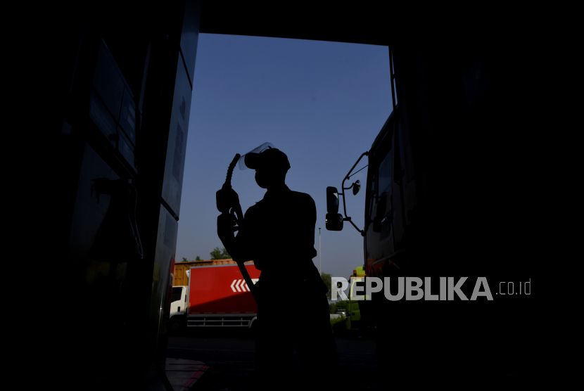 Siluet petugas melayani pengisian BBM di SPBU (ilustrasi).