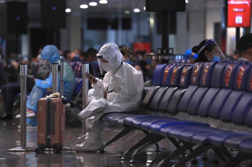 Penumpang menggunakan telepon saat menunggu untuk naik pesawat di bandara Tan Son Nhat di kota Ho Chi Minh, Vietnam, Jumat, 15 Oktober 2021. Polisi Vietnam menangkap Wakil Luar Negeri To Anh Dung.