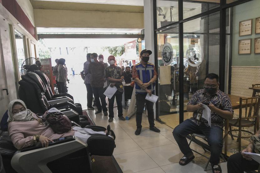 Sejumlah orang antre untuk mendapatkan vaksin COVID-19 penguat (booster) di rest area km 19, Tambun, Kabupaten Bekasi, Jawa Barat, Kamis (27/1/2022). Pemerintah setempat menyediakan 200 vaksin dosis ketiga untuk pengendara yang melintas di tol Jakarta-Cikampek sebagai upaya mendukung pemerintah dalam mempercepat penanggulangan pandemi COVID-19.