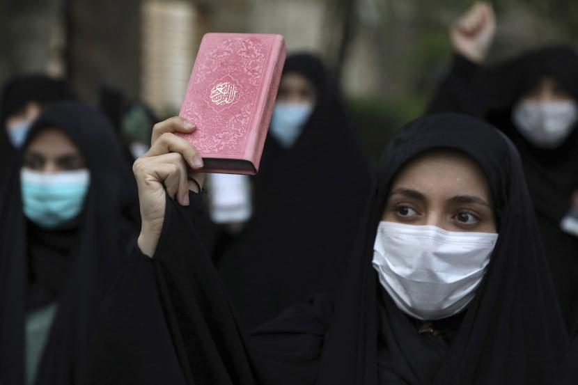 Seorang pengunjuk rasa memegang salinan Alquran, kitab suci umat Islam, selama demonstrasi mengutuk rencana pembakaran Alquran oleh kelompok sayap kanan di Swedia (ilustrasi).