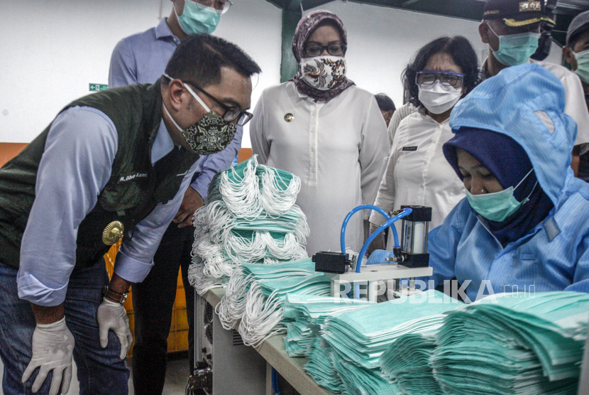 Gubernur Jawa Barat Ridwan Kamil (kiri) didampingi Bupati Bogor Ade Yasin (tengah) melihat produksi  pembuatan masker medis di PT Multi One Plus, Gunung Putri, Kabupaten Bogor,  Jawa Barat, Rabu (15/4/2020). Kunjungan Gubernur tersebut untuk memastikan ketersediaan Alat Pelindung Diri (APD) bagi kebutuhan Jawa Barat dan nasional