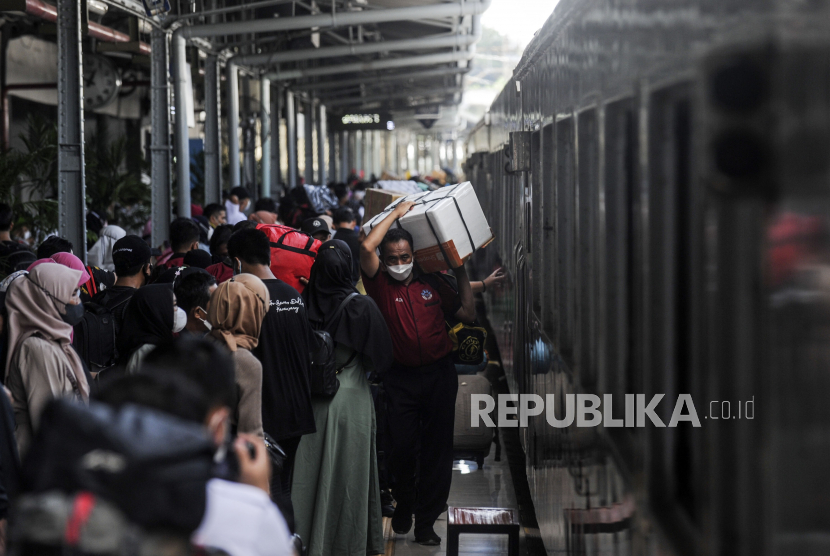 Porter membawa barang bawaan penumpang di Stasiun Pasar Senen, Jakarta Pusat, Rabu (27/4/2022).