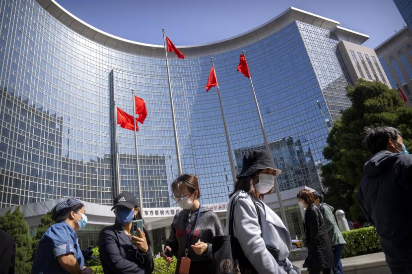 Orang-orang yang memakai masker wajah mengantre untuk tes virus corona di sebuah gedung perkantoran di distrik Dongcheng, Beijing, Selasa, 26 April 2022. Beijing akan melakukan pengujian massal terhadap sebagian besar dari 21 juta orangnya, otoritas mengumumkan Senin, sebagai COVID- baru.