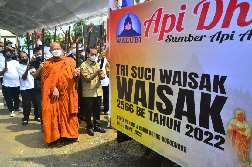 Umat Buddha membawa Api Dharma Waisak menggunakan obor usai mengambil dari sumber Api Abadi Mrapen di Desa Manggarmas, Godong, Grobogan, Jawa Tengah, Sabtu (14/5/2022). Prosesi pengambilan api abadi yang kemudian disemayamkan di Candi Mendut dan dibawa menuju altar utama di Candi Borobudur pada puncak prosesi tersebut merupakan rangkaian dari ritual jelang Hari Raya Waisak 2566 BE/2022.