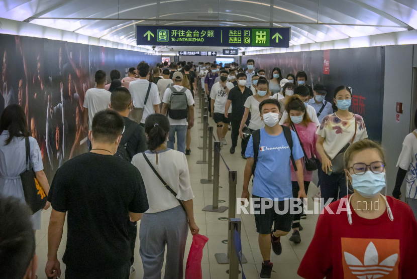 Orang-orang yang memakai masker wajah untuk membantu melindungi diri dari COVID-19 berjalan melalui stasiun kereta bawah tanah pada jam sibuk pagi hari di Beijing, Rabu, 4 Agustus 2021. Beijing menutup puluhan stasiun metro dan rute bus pada Rabu (4/5/2022), untuk menghentikan penyebaran Covid-19.