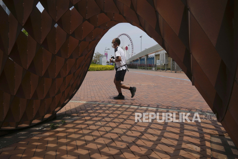 Seorang pria joging di sebuah taman di Hong Kong, Kamis, 5 Mei 2022. Hong Kong pada Kamis membuka kembali pantai dan kolam renang dalam pelonggaran pembatasan COVID-19, sementara ibu kota China, Beijing, mulai melonggarkan aturan karantina bagi pendatang dari luar negeri.