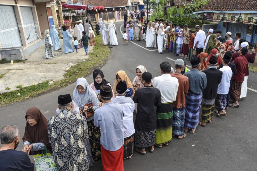 Sejumlah warga bersalaman usai melaksanakan salat Idul Fitri 1443 Hijriyah di Desa Darmaraja, Kabupaten Ciamis, Jawa Barat, Senin (2/4/2022). Menteri Kesehatan Budi Gunadi Sadikin meyakini akan terjadi kenaikan kasus Covid-19 pascalibur lebaran.