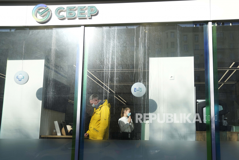 Seorang pelanggan, kiri, dan seorang karyawan di kantor Sberbank, di Moskow, Rusia, Rabu, 2 Maret 2022. Jepang menambah sanksi untuk Rusia.