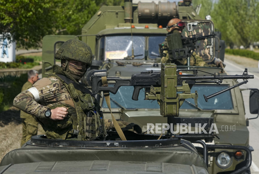 FILE - Prajurit Rusia bersenjata berdiri di atas kendaraan militer mereka di dekat Pembangkit Listrik Tenaga Nuklir Zaporizhzhia, pembangkit listrik tenaga nuklir terbesar di Eropa dan di antara 10 terbesar di dunia, di Enerhodar, wilayah Zaporizhzhia, di wilayah di bawah kendali militer Rusia, tenggara Ukraina, Mei 1, 2022.