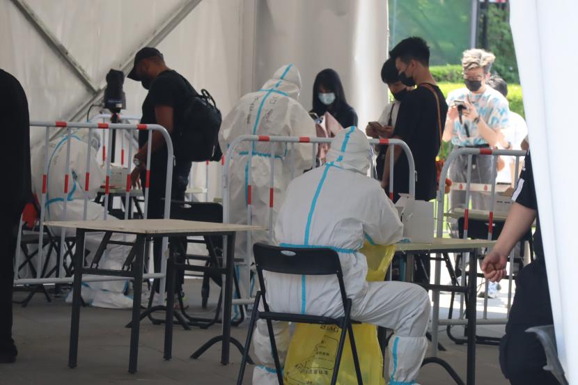 Petugas kesehatan mengambil sampel dari warga dalam tes PCR massal putaran terakhir di Distrik Chaoyang, Beijing, China, Rabu (18/5/2022). Sejak 22 April 2022, Beijing menggelar sedikitnya lima putaran tes PCR massal, setiap putaran tediri dari tiga kali tes bagi setiap warga, seiring dengan mewabahnya gelombang terkini COVID-19 varian Omicron.