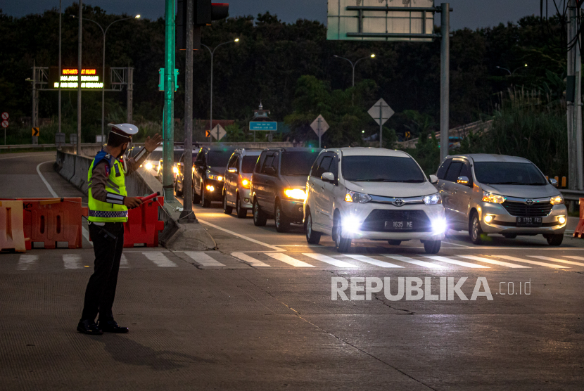 Petugas kepolisian mengatur lalu lintas kendaraan roda empat dari arah Jakarta yang akan keluar Gerbang Tol Kaliwungu, Kabupaten Kendal, Jawa Tengah, Jumat (29/4/2022). Pihak kepolisian melakukan skema pecah arus ke pintu keluar gerbang tol tersebut guna mengantisipasi terjadinya kemacetan atau penumpukan kendaraan roda empat dari arah Jakarta yang akan menuju Gerbang Tol Kalikangkung Semarang.