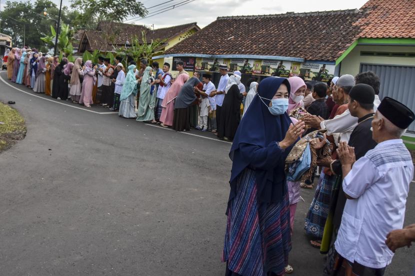 Sejumlah warga bersalaman usai melaksanakan shalat Idul Fitri 1443 Hijriyah di Desa Darmaraja, Kabupaten Ciamis, Jawa Barat, Senin (2/4/2022). Tradisi bersalaman massal Lebaran antar Dusun atau Kampung dilaksanakan kembali setelah dua tahun Pemerintah memberlakukan Pemberlakuan Pembatasan Kegiatan Masyarakat (PPKM) akibat pandemi COVID-19.