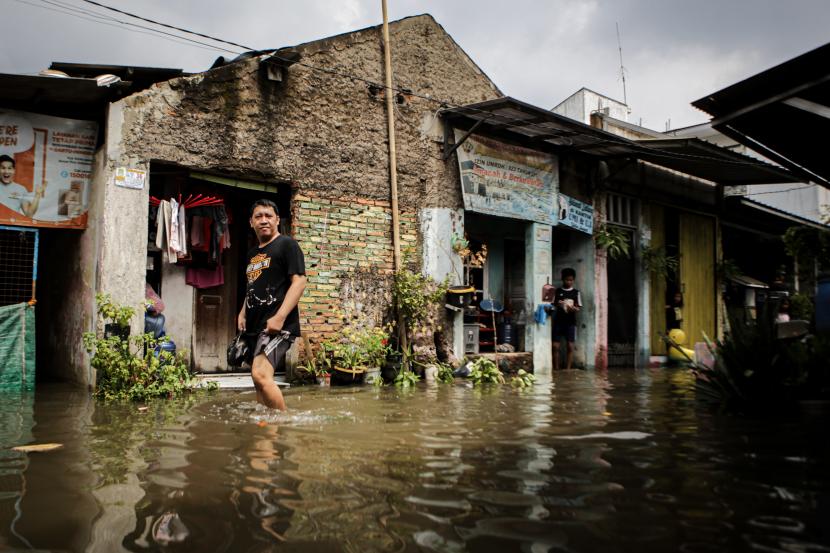 Seorang warga berjalan melintasi banjir di Margasari, Karawaci, Tangerang, Banten, Rabu (11/5/2022). Pemkab Tangerang segera perbaiki drainase jalan guna antisipasi banjir.