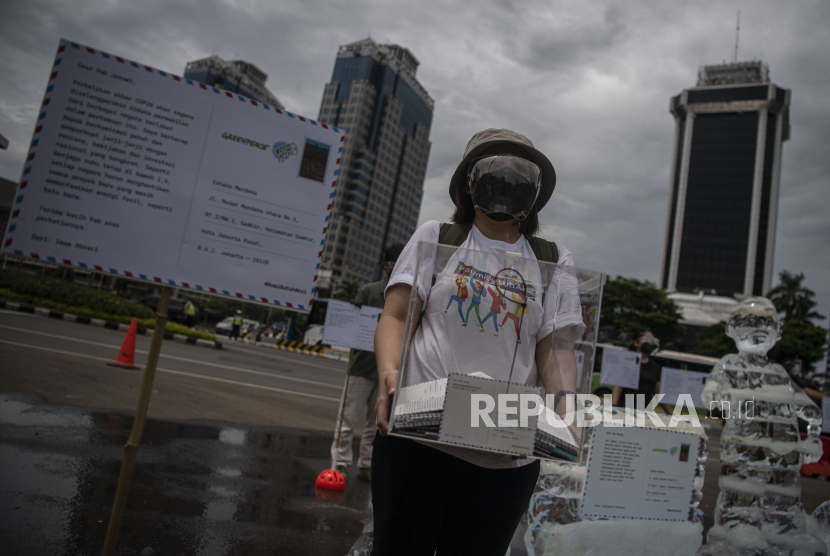 Aktivis Greenpeace Indonesia melakukan aksi di kawasan Monumen Nasional, Jakarta, Rabu (10/11/2021). Aksi mengantarkan 1.000 kartu pos dari masyarakat seluruh Indonesia kepada Presiden Joko Widodo yang disertai patung es seorang anak tersebut untuk mengingatkan adanya ancaman besar perubahan iklim.