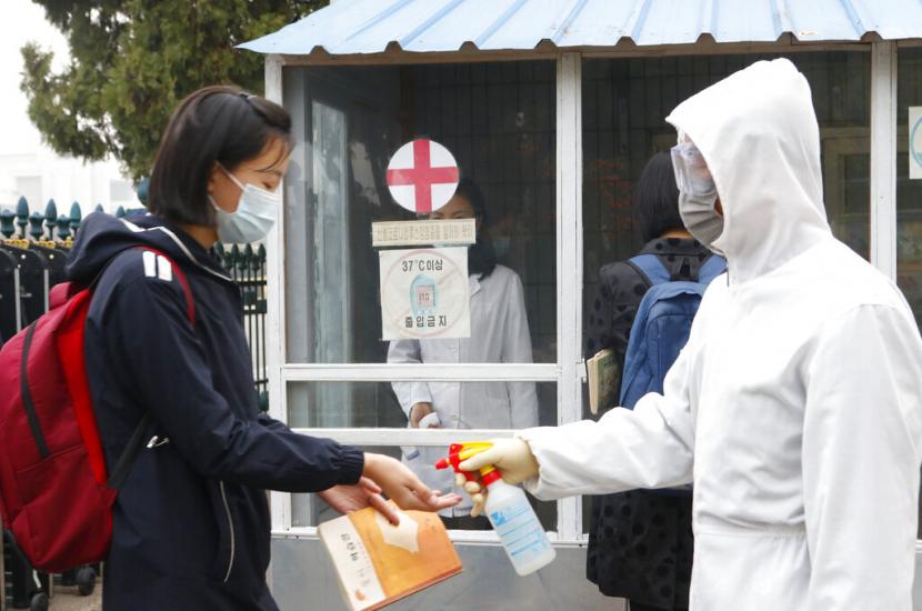 Seorang siswi mengenakan masker wajah, mendisinfeksi tangannya sebelum memasuki Sekolah Menengah Kumsong No. 2 di pagi hari di Pyongyang, Korea Utara, pada 3 November 2021. Korea Utara mengumumkan infeksi virus corona pertamanya setelah lebih dari dua tahun menjadi pandemi pada Kamis, 12 Mei 2022 ketika pemimpin Kim Jong Un menyerukan untuk meningkatkan langkah-langkah pencegahan COVID-19 ke tingkat maksimum.