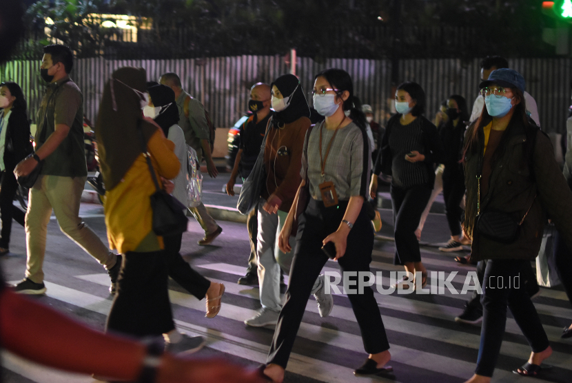 Sejumlah pekerja melintas di pelican cross kawasan Sudirman, Jakarta, Selasa (17/5/2022).  Presiden Joko Widodo melonggarkan kebijakan terkait aturan pemakaian masker dengan  memperbolehkan warga tidak mengenakan masker di luar ruangan apabila tidak dalam kondisi kerumunan menyusul kondisi pandemi COVID-19 di Indonesia saat ini terkendali.