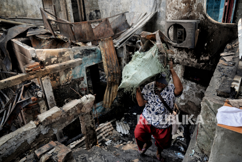 Warga membawa puing bangunan di lokasi terdampak kebakaran di kawasan Pasar Gembrong, Jakarta, Senin (25/4/2022). Sebanyak 400 rumah dan pertokoan dikawasan tersebut terbakar pada Ahad (24/4) sekitar pukul 21.00 WIB yang diduga akibat korsleting listrik. Menurut Ikatan Pedagang Pasar Indonesia, kerugian akibat kebakaran di Pasar Gembrong tersebut ditaksir sekitar Rp 2 miliar. Republika/Thoudy Badai