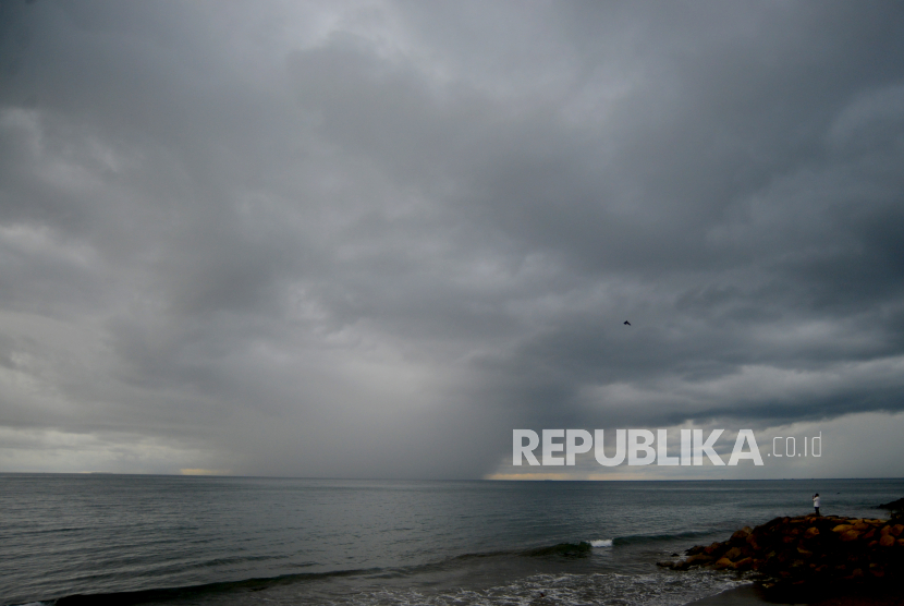 Warga melihat awan hujan di Pantai Padang, Sumatera Barat, Kamis (9/12/2021). Badan Meteorologi Klimatologi dan Geofisika (BMKG) memprediksi sejumlah kota besar di Indonesia turun hujan.