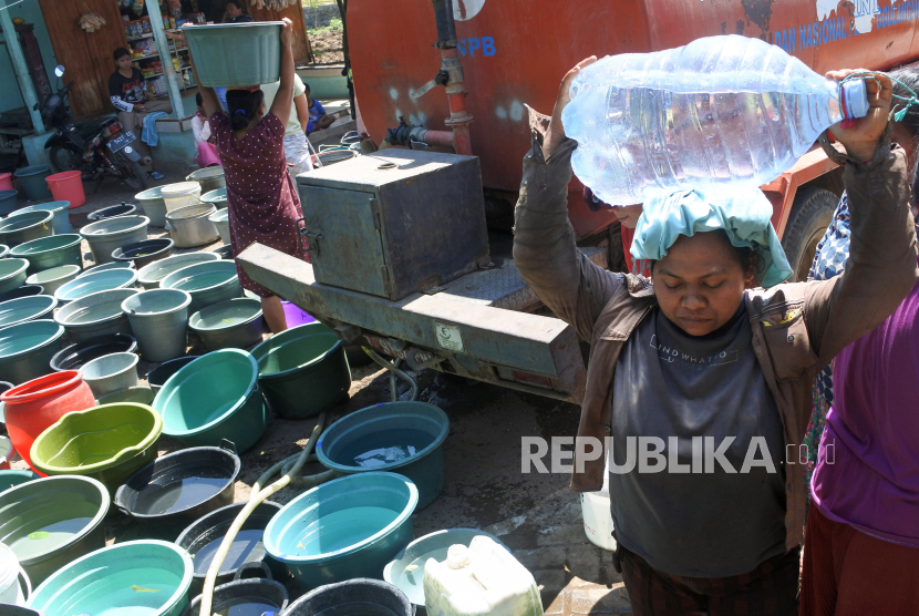 Warga membawa air bersih yang didistribuskan Badan Penanggulangan Bencana Daerah (BPBD).
