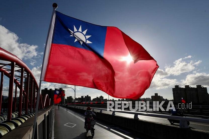 Orang-orang melewati pemasangan bendera Taiwan menjelang perayaan Hari Nasional di Taipei, Taiwan, 6 Oktober 2021.
