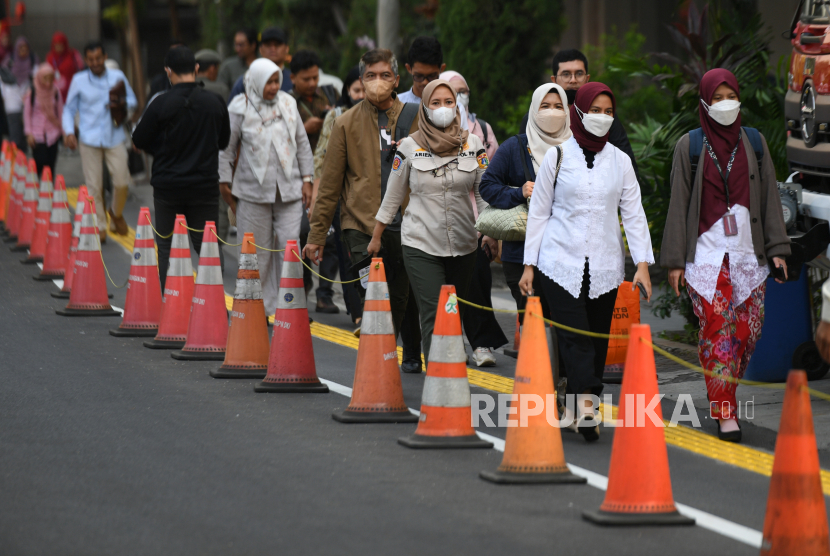 Pegawai Pemprov DKI Jakarta berjalan keluar saat jam pulang kerja di depan Balai Kota, Jakarta, Jumat (18/8/2023). Pemerintah Provinsi DKI Jakarta melakukan uji coba kebijakan work from home (WFH) 50 persen bagi Aparatur Sipil Negara (ASN) Pemprov DKI Jakarta dimulai 21 Agustus 2023 untuk mengurangi kemacetan dan polusi udara serta memberikan kenyamanan saat KTT ASEAN berlangsung di Jakarta.