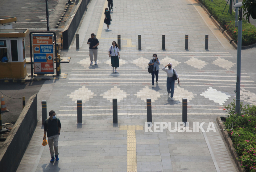 Warga melintas memakai masker untuk melindungi diri dari debu, di dekat  Jembatan Penyeberangan Sepeda (JPS) sekaligus Jembatan Penyeberangan Orang (JPO) di Jalan Sudirman,Jakarta, Selasa (8/8/2023). Pemprov DKI Jakarta mengimbau warga menggunakan masker untuk mengantisipasi polusi udara di Ibu Kota akibat polusi udara Jakarta dinilai sangat buruk. 