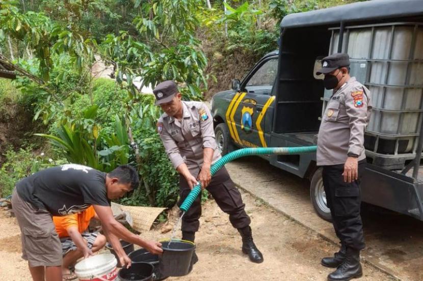 Polisi menyalurkan air bersih yang diusung menggunakan mobi patroli modifikasi tangki air.