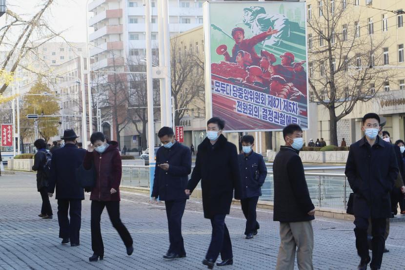 Warga berjalan dengan mengenakan masker di jalan sepanjang Stasiun Kereta Api Pyongyang di Distrik Pusat Pyongyang, Korea Utara, Jumat (4/11/2022).