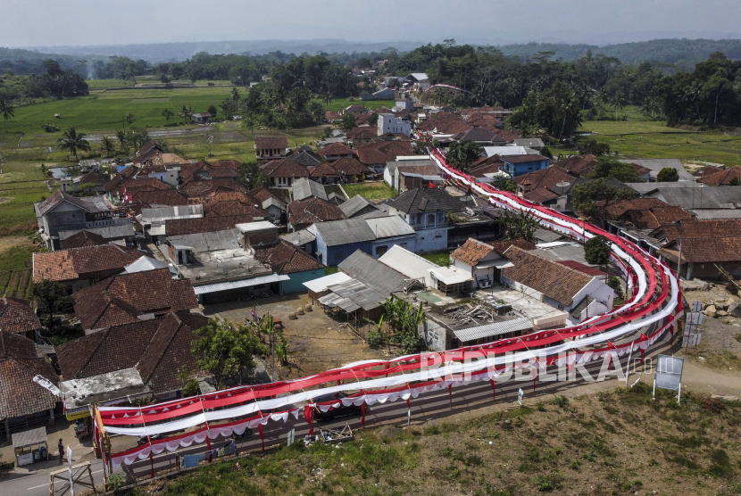 Foto udara lorong bendera Merah Putih bertema Terus Melaju untuk Indonesia Maju yang terbentang di Desa Sukamenak, Kabupaten Tasikmalaya, Jawa Barat, Sabtu (12/8/2023). Lorong bendera Merah Putih yang menghiasi jalan perkampungan sepanjang 250 meter itu dibuat warga secara swadaya dalam rangka memeriahkan HUT ke-78 Kemerdekaan RI.