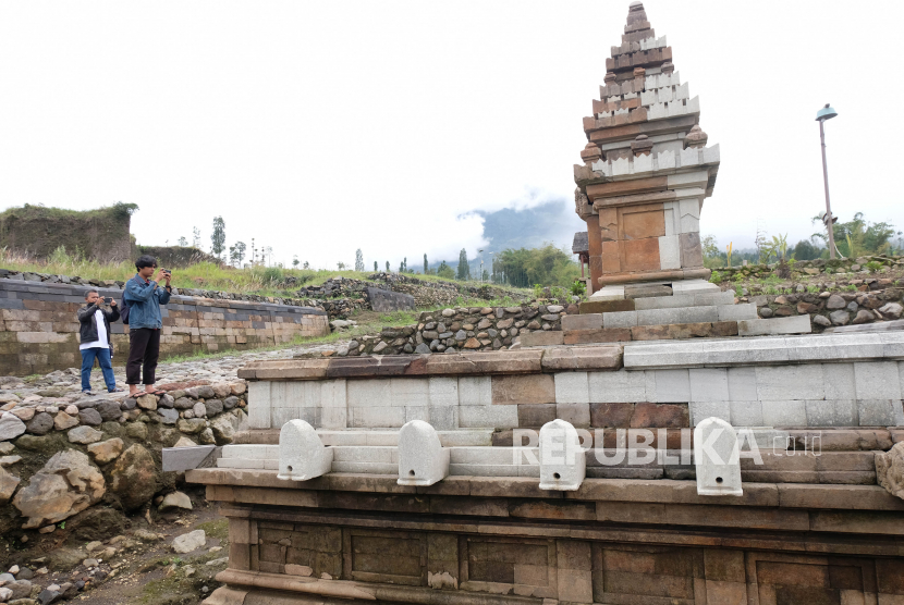 Pengunjung memotret bangunan candi yang telah selesai direstorasi di situs Liyangan kawasan lereng gunung Sindoro Dusun Liyangan, Purbosari, Ngadirejo, Temanggung, Jawa Tengah, Kamis (11/11/2021). Balai Pelestarian Cagar Budaya (BPCB) Provinsi Jawa Tengah melaksanakan pemugaran sejumlah bangunan bersejarah di situs Liyangan yang merupakan peninggalan Mataram kuno agar bisa utuh menyerupai bentuk aslinya.