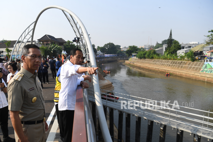 Presiden Joko Widodo (kanan) didampingi Pj Gubernur DKI Jakarta Heru Budi Hartono (kiri) melihat aliran sungai usai meresmikan sodetan Kali CIliwung. Politikus PSI kembali menyindir Anies.
