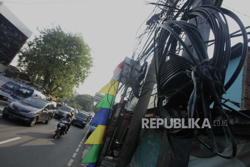 Kabel jaringan utilitas yang semrawut di kawasan Palmerah, Jakarta Barat, Jumat (4/8/2023). Keberadaan kabel jaringan utilitas yang semrawut di Jakarta tersebuf mengganggu keindahan estetika kota serta dapat membahayakan keselamatan pejalan kaki maupun pengendara yang melintas.